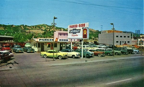 A used car lot from the 1950s, named Parker-Robb Chevrolet, and featuring a number of classic Chevys.